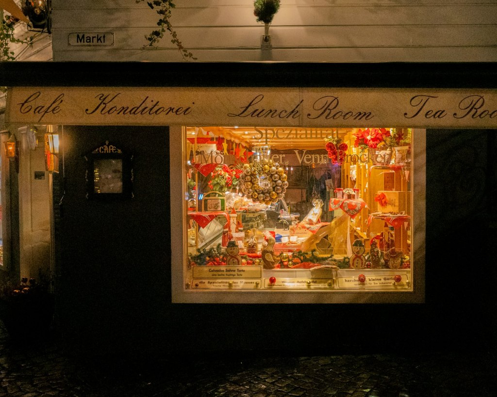 A cosy café window lit up with colourful festive decorations