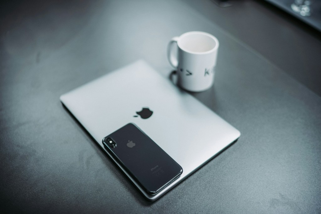 Laptop and coffee mug on a desk, ready to write an email newsletter.